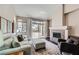 Comfortable living room with a stone fireplace, large windows, and a cozy seating arrangement at 7636 Sudan Ct, Las Vegas, NV 89149