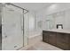 Bright bathroom featuring a glass-enclosed shower, soaking tub, and dark wood vanity at 788 Grand Country Ave, North Las Vegas, NV 89086