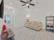 Bright living room featuring neutral carpet, a beige sofa, ceiling fan, and modern shelving for stylish storage at 788 Grand Country Ave, North Las Vegas, NV 89086