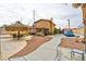 View of the home's backyard with a covered patio, tiki umbrella, gravel area, and access to driveway at 8504 Soneto Ln, Las Vegas, NV 89117