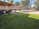 Backyard featuring grass, a pool and pool house, and a covered patio at 8504 Soneto Ln, Las Vegas, NV 89117