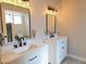 Bathroom featuring double sinks, modern light fixtures and black hardware at 8504 Soneto Ln, Las Vegas, NV 89117