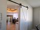 View into kitchen with barn door, featuring custom wood ceiling, white cabinetry, and modern appliances at 8504 Soneto Ln, Las Vegas, NV 89117