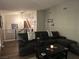 Inviting living room featuring hardwood floors, a modern metal railing, and a comfortable leather sofa at 8504 Soneto Ln, Las Vegas, NV 89117