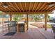 Outdoor kitchen and dining area with built-in grill, mini-fridge, covered patio, and a thatched tiki umbrella at 8504 Soneto Ln, Las Vegas, NV 89117