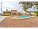 Backyard view of the fenced pool area with a diving board, gravel, greenery and home view at 8504 Soneto Ln, Las Vegas, NV 89117