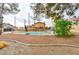 Fenced-in pool with a diving board, gravel landscaping, some greenery, and partial home view at 8504 Soneto Ln, Las Vegas, NV 89117