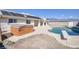 Relax and unwind in this backyard featuring a pool, hot tub, and covered patio for entertaining at 881 W Kathryn Ave, Pahrump, NV 89060
