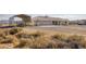 Exterior view of the house, metal building, and an unlandscaped yard at 881 W Kathryn Ave, Pahrump, NV 89060