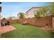A backyard view with artificial grass, a brick firepit, and brick perimeter wall at 9107 Wine Cellar Ave, Las Vegas, NV 89148