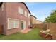 A cozy backyard featuring artificial grass, a brick firepit, and brick perimeter wall at 9107 Wine Cellar Ave, Las Vegas, NV 89148