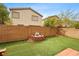 A backyard view with artificial grass, a brick firepit, and brick perimeter wall at 9107 Wine Cellar Ave, Las Vegas, NV 89148
