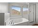 Modern bathroom features a jetted tub, separate glass enclosed shower, and a view of the outdoors at 9107 Wine Cellar Ave, Las Vegas, NV 89148