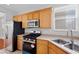Kitchen features oak cabinets, stainless steel appliances, double sink and window at 9107 Wine Cellar Ave, Las Vegas, NV 89148