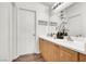Bathroom featuring double sinks with wood cabinets, a decorative mirror, and white walls at 9322 Straw Hays St # 101, Las Vegas, NV 89178