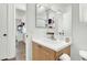 Bright bathroom featuring a modern sink, decorative mirrors, and a view into the adjacent bedroom at 9322 Straw Hays St # 101, Las Vegas, NV 89178