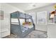 Bedroom with bunk beds and a neutral color palette featuring a large window and grey area rug at 9322 Straw Hays St # 101, Las Vegas, NV 89178