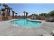 Community pool featuring clear blue water, lounge chairs, palm trees, and protective fencing at 9322 Straw Hays St # 101, Las Vegas, NV 89178
