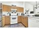 Well-equipped kitchen featuring wood cabinets, white appliances, and stylish decorative touches at 9322 Straw Hays St # 101, Las Vegas, NV 89178