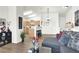 Bright, airy living room featuring a modern gray sofa, wood flooring, and a view into the adjacent kitchen at 9322 Straw Hays St # 101, Las Vegas, NV 89178