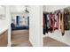 View from the bathroom into the main bedroom and walk-in closet with hanging clothes at 9322 Straw Hays St # 101, Las Vegas, NV 89178