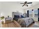 Bright main bedroom featuring wood-look floors, a ceiling fan, and a gray bedframe with storage drawers at 9322 Straw Hays St # 101, Las Vegas, NV 89178