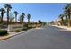Arlington Ranch community entrance with lush landscaping and palm trees lining the street at 9322 Straw Hays St # 101, Las Vegas, NV 89178