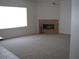 Spacious carpeted living room featuring a cozy fireplace and bright window at 10112 Plomosa Pl, Las Vegas, NV 89134