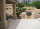Covered patio with a built-in grill, seating area, and access to the landscaped backyard at 10112 Plomosa Pl, Las Vegas, NV 89134