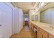Hallway view of the bathroom with a double vanity, closets and access to bedroom at 10720 Bennington Ct, Las Vegas, NV 89134