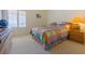 Comfortable bedroom featuring a bed with colorful patterned bedding and a dresser by the window at 10720 Bennington Ct, Las Vegas, NV 89134