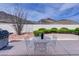 Outdoor patio area with seating, a grill, well-maintained landscaping, and mountain views at 10720 Bennington Ct, Las Vegas, NV 89134