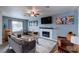 Bright living room featuring a cozy fireplace, ceiling fan, and multiple seating areas at 117 Saint Albans Ct, Henderson, NV 89015