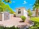 View of the side yard and detached garage with gravel landscaping, and a small storage shed at 1601 Fairgate Ct, Las Vegas, NV 89117