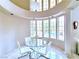 Cozy dining room with large windows overlooking the pool, tiled floors and a modern glass table set at 1601 Fairgate Ct, Las Vegas, NV 89117