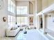 Bright living room with high ceilings, a wall of windows, tiled floors and a cozy seating area at 1601 Fairgate Ct, Las Vegas, NV 89117