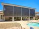 Covered patio with motorized privacy screens, steps to a pool with rock detail and a seating area at 1601 Fairgate Ct, Las Vegas, NV 89117