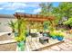 Backyard patio and seating area with a wooden pergola and potted plants at 1601 Fairgate Ct, Las Vegas, NV 89117