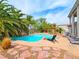 Inviting backyard pool with lush landscaping, lounge chairs, and a covered pergola, perfect for relaxation at 1601 Fairgate Ct, Las Vegas, NV 89117