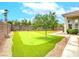 Backyard with an artificial turf putting green, attractive landscaping, and a view of the home's exterior at 1601 Fairgate Ct, Las Vegas, NV 89117