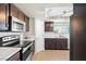 Bright kitchen with dark wood cabinets, stainless microwave, white subway tile backsplash, and lots of natural light at 1720 S Blagg Rd, Pahrump, NV 89048