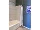 Cozy bathroom features a bathtub with white tile surround and blue accent wall with artwork at 217 Big Horn Dr # 3, Boulder City, NV 89005