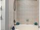 Well-lit bathtub with beige tile surround and recessed shelving with decor at 217 Big Horn Dr # 3, Boulder City, NV 89005