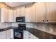 Kitchen detail shot showcasing white cabinets, granite countertops, and black appliances at 217 Big Horn Dr # 3, Boulder City, NV 89005