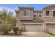Townhouse with a two car garage, desert landscaping, and neutral toned stucco at 223 Positive Point St, Henderson, NV 89012