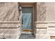 Close up of a blue front door with a welcome mat and stone detailing at 223 Positive Point St, Henderson, NV 89012