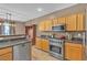Bright kitchen with stainless steel appliances and wooden cabinets, and wooden floors at 223 Positive Point St, Henderson, NV 89012