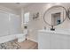 Bright bathroom features modern vanity, round mirror, shower-tub combo and neutral tones at 2504 Courlan Dr, North Las Vegas, NV 89084