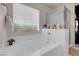 Relaxing soaking tub beside enclosed shower with natural light beaming through window at 2504 Courlan Dr, North Las Vegas, NV 89084