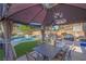 View of the patio and backyard featuring an outdoor dining area, pool, spa, and privacy wall at 2504 Courlan Dr, North Las Vegas, NV 89084